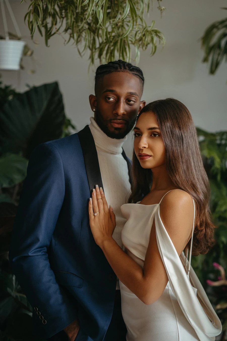 A couple standing together among greenery