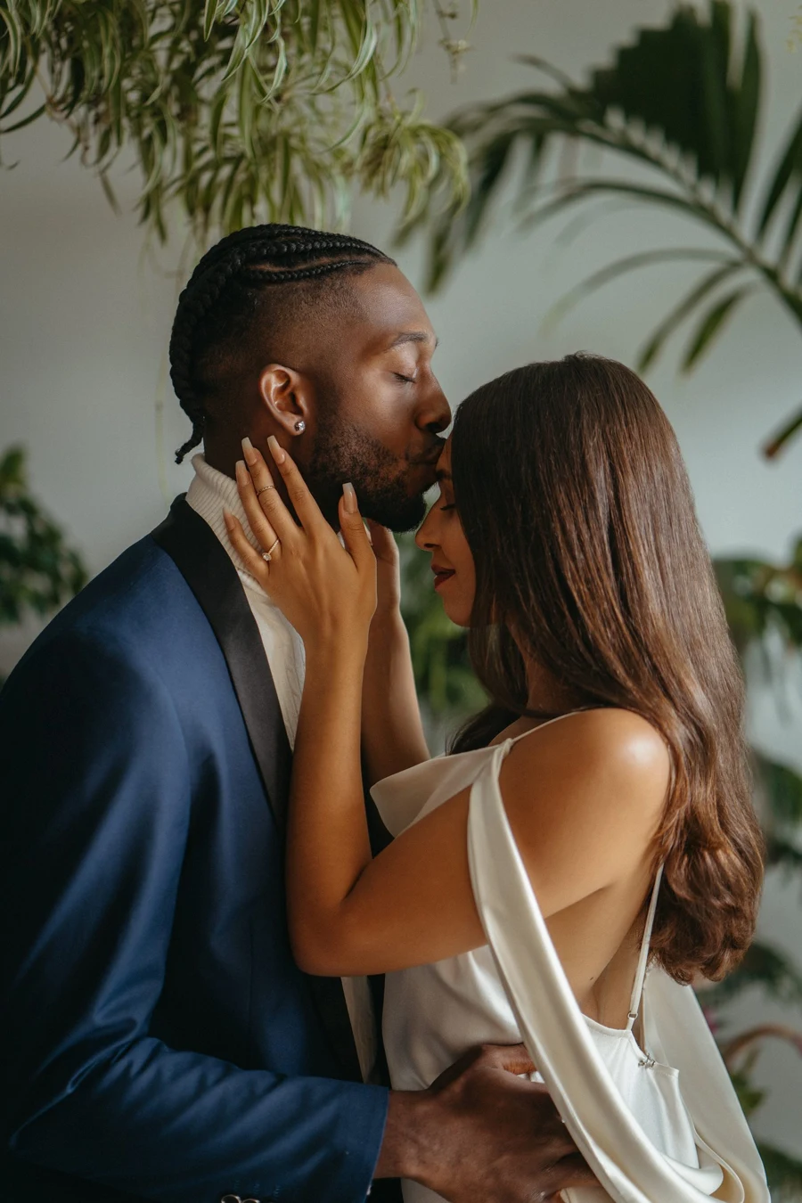 A couple sharing a quiet forehead kiss